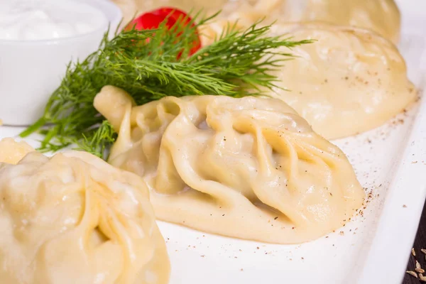 Steam dumplings with stuffing of a lamb and onions, is served with sour cream — Stock Photo, Image