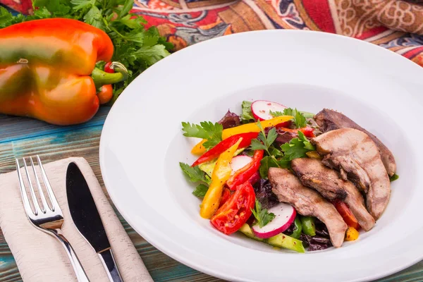 Mutton uvulas with salad and paprika, is served in dressing from olive oil