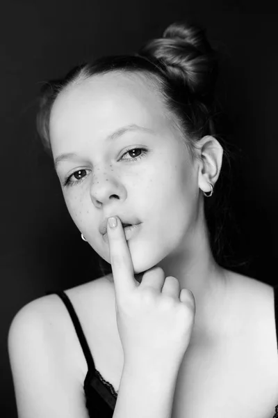 A menina com sardas mantém um dedo sobre uma boca — Fotografia de Stock