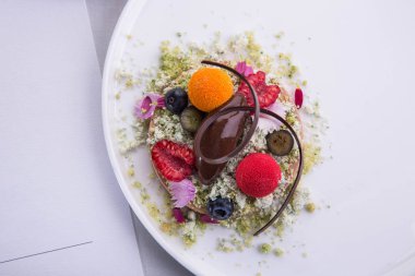 Çikolatalı dondurma, sorbe bitter çikolata, ahududu ve deniz topalak şekerler ve yenilebilir çiçekler