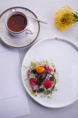 Yenilebilir çiçekler ve bir fincan çay ile çikolata sorbe