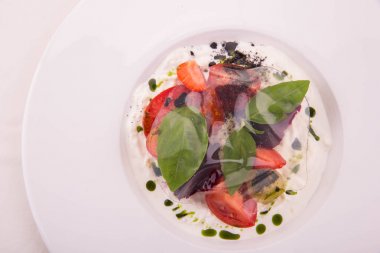 Bir stachatell, genç pancar, çilek ve fesleğen, peynirli tatlı domates süsleme üzerinden saydam domates su jöle ile servis edilir