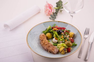 Nisuaz. Tataki üzerinden bir ton balığı, taze sebze, zeytin, patates ve Yeşiller