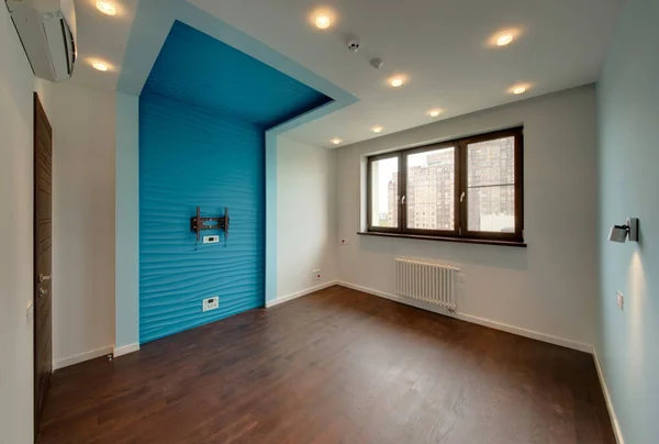 The room with a blue insert under the TV and a brown window