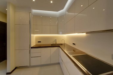 Bir mutfak çalışma yüzeyi ile bir lavabo ve başucu masaları