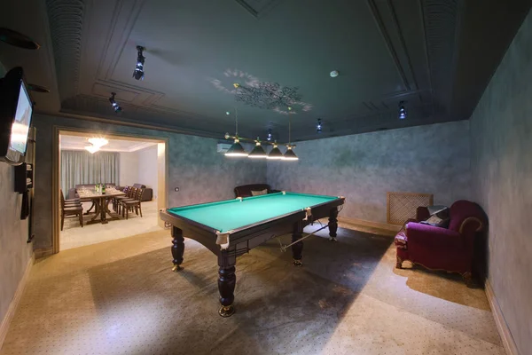 The billiard room with lamps and a sofa, the TV and a son of lumiere