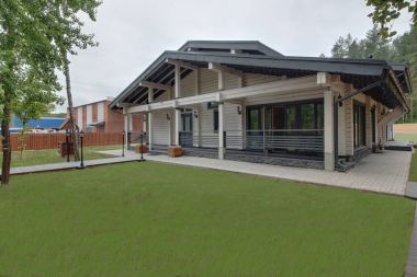 The building on a green clearing with wooden beams and piles clipart