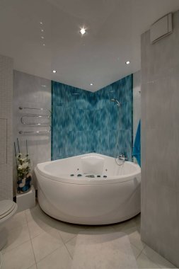A jacuzzi bathtub with a blue marble wall, a light tile on a floor and walls clipart