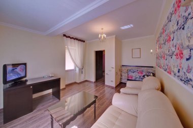 Beyaz döşemeli mobilya bir çıkış bir balkon, Tv ve bir sehpa ile hafif bir çizim odasında