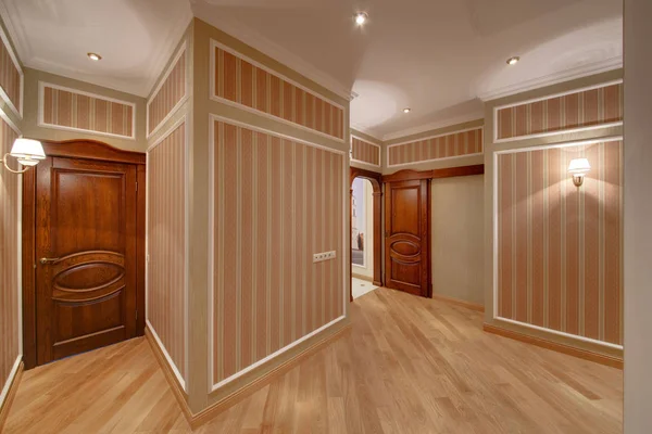 ストライプの壁 美しい木製のドアと壁のランプと広々 とした廊下 — ストック写真
