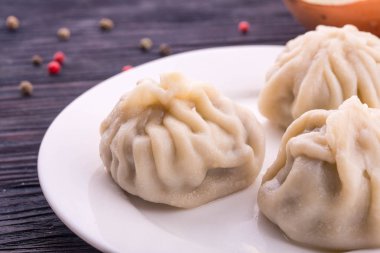 Dumplings with meat from mutton, are served boiled on a white plate clipart
