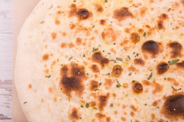 Pizza focaccia rendelenmiş peynir ve yeşillik ile