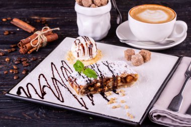 Fındıklı elmalı turta, vanilyalı dondurma ile servis edilir.