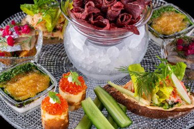 Buzlu sümüklü et, kırmızı havyarlı krep, cam tepside balık çerezi.