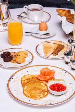 Otelde kahvaltı, krep, kurabiye, portakal suyu, bir fincan kahve.