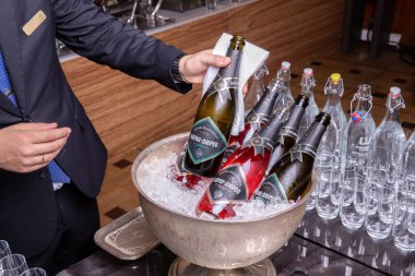 Sommelier restoranda şampanya şişelerini sunar.