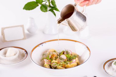 Soğanlı et köftesi, et suyu ve sebzeyle servis edilir.