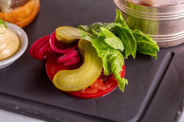 Salatalık turşusu, marul yaprağı ve taze domates.