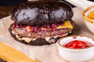 Pirzola ve ketçaplı siyah hamburger.