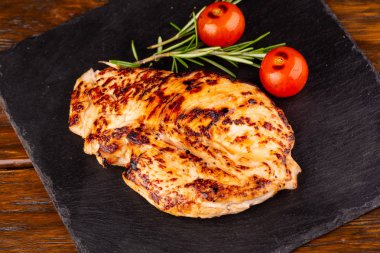 Kızarmış tavuk bifteği, sebzelerle servis edilir.