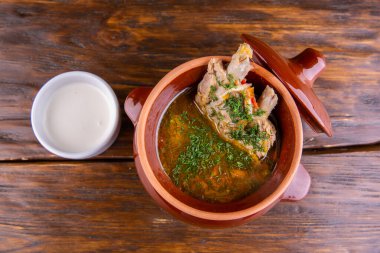 Et kaburgalı çorba, ekşi krema ve yeşillikle servis edilir.