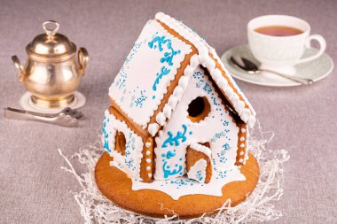 Beyaz duvarlı ve mavi desenli zencefilli kurabiye evi.