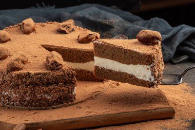 İçinde hurma, kurutulmuş meyve ve çikolata tozu olan bir parça kek.