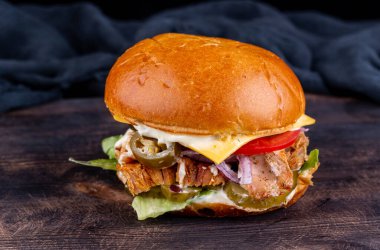 Domuz etli hamburger, peynir, domates, biber ve turşu.