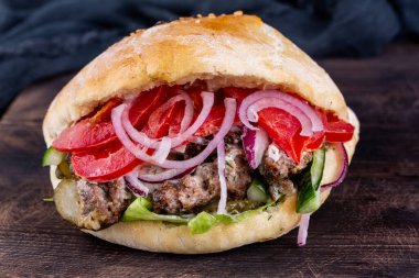 Farklı et parçaları, kırmızı soğan ve taze domateslerle hamburger karışımı.
