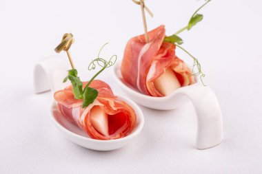 Pastırmalı kanepe ve beyaz arka planda yeşillikli kavun.