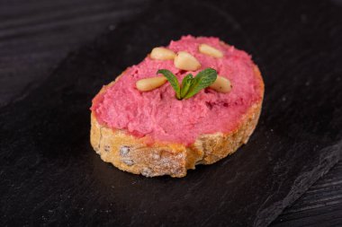 Siyah arka planda balık, et ve sebzeli çeşitli tost kanapeleri.