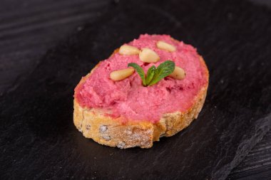 Siyah arka planda balık, et ve sebzeli çeşitli tost kanapeleri.