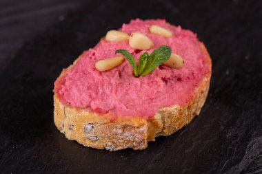 Siyah arka planda balık, et ve sebzeli çeşitli tost kanapeleri.