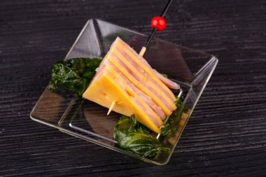 Peynir ve jambon kanepesi, marul yapraklarıyla servis edilir.