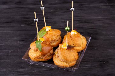 Bir parça tavuk, sığır eti ve ördekle kanepede, yeşilliklerle servis edilir.