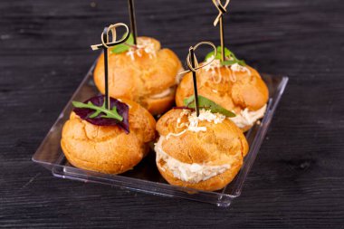 Bir parça tavuk, sığır eti ve ördekle kanepede, yeşilliklerle servis edilir.