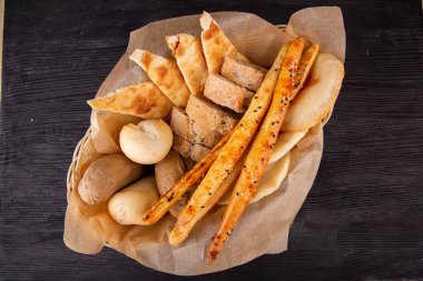 Siyah beyaz ekmekli ekmek sepeti, tortilla ve çıtır çıtır çubuklar.