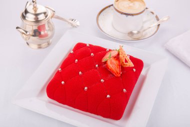 Çilekli kırmızı kadife pasta ve gümüş karamel topları.