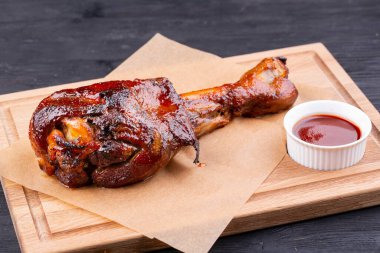 Izgarada pişmiş domuz eti ketçapla servis edilir.