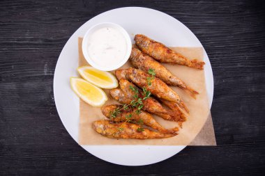 Kömürde kavrulmuş davul, limon ve ekşi kremayla servis edilmiş.