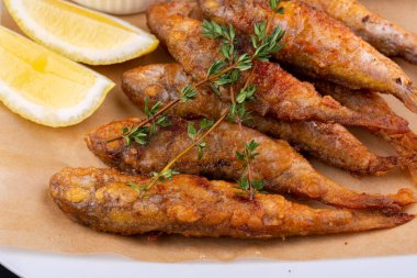 Kömürde kavrulmuş davul, limon ve ekşi kremayla servis edilmiş.