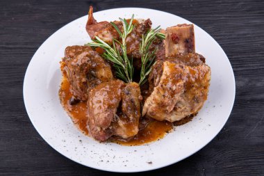 Kemiğin üzerinde baharatla pişirilmiş et sosla servis edilir.