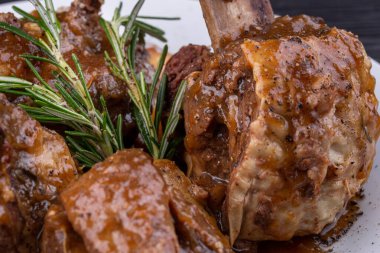 Kemiğin üzerinde baharatla pişirilmiş et sosla servis edilir.