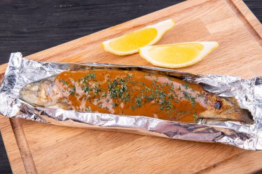 Soslu ve otlu folyoda pişmiş alabalık.