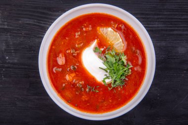 Yeşillik ve limonlu Solyanka, ekmekle sıcak servis edilir.