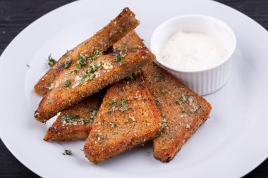 Yeşillik ve krema sosuyla servis edilen siyah ekmekten sarımsaklı ızgara.