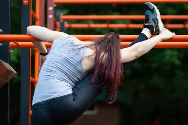 Genç atletik kadın esneme egzersizleri yapıyor.