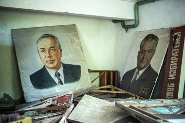 Terk edilmiş bir binadaki SSCB liderlerinin portreleri.