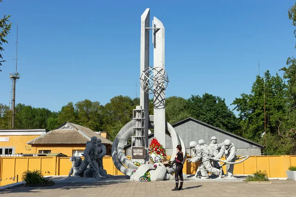 Monumento a los que salvaron el mundo. Una chica mira un monumento a los liquidadores del accidente de Chernobyl — Foto de Stock