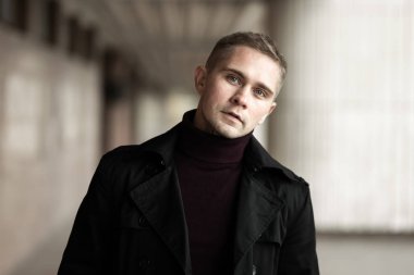 Siyah trençkotlu şık adam.